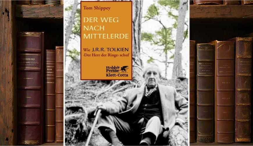 Buchcover von Der Weg nach Mittelerde von Tom Shippey: Schwarz-weiß-Foto von J. R. R. Tolkien, wie er mit Spazierstock an einen Baum gelehnt im Wald sitzt. Links oben ein orangefarbenes Textfeld mit Titel und Unterzeile: ‚Wie J. R. R. Tolkien Der Herr der Ringe schuf‘. Verlag: Hobbit Presse Klett-Cotta.