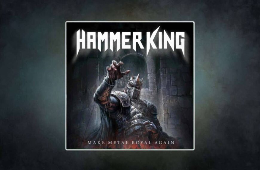 Hammer King – Make Metal Royal Again Albumcover: Ein finsterer, gepanzerter König mit Dornenkrone und maskiertem Gesicht steht in einer steinernen Festung. Er streckt eine Hand nach vorn, an der Marionettenfäden hängen, als würde er unsichtbare Figuren kontrollieren. Der Hintergrund ist dunkel und bedrohlich, der Albumtitel prangt in metallischer Schrift darunter.