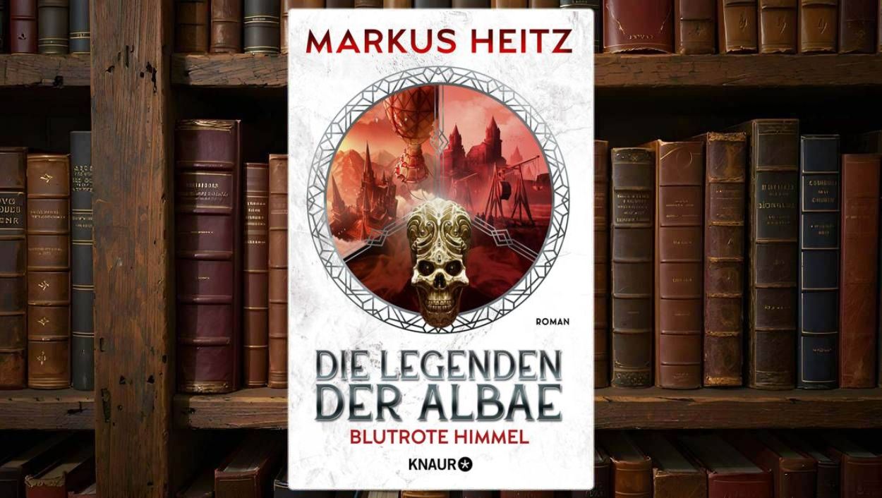 Cover von Die Legenden der Albae – Blutrote Himmel: weißer Hintergrund mit rundem Medaillon-Motiv. Darin eine düstere Fantasy-Szene mit roten Wolken, Luftschiffen und Burgen, im Vordergrund ein goldverzierter Schädel. Der Titel prangt in grauen Lettern, blutrot unterstrichen.