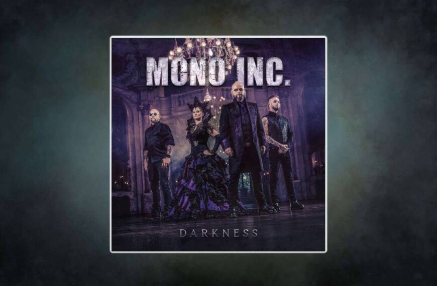 Die Band Mono Inc. steht in opulenten schwarz-violetten Gewändern in einem prunkvollen Ballsaal, die Kronleuchter glitzern – dramatische Gothic-Ästhetik trifft aristokratische Dunkelheit.