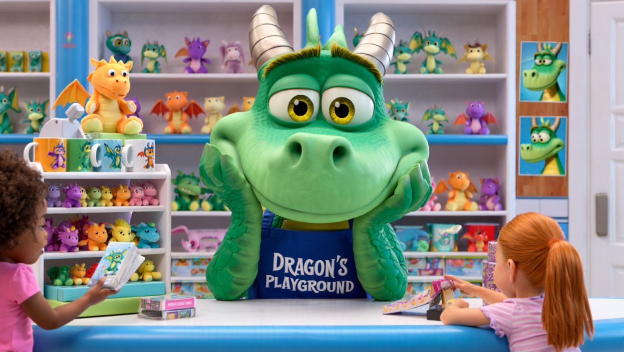 Ein großer, cartoonhafter Drache sitzt gelangweilt hinter einer Ladentheke in einem Drachen-Spielzeugladen. Um ihn herum stehen Plüschdrachen, Tassen und Merchandising-Produkte, während Kinder begeistert einkaufen.