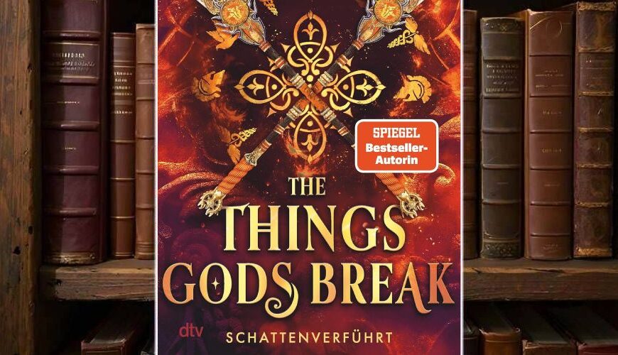 Cover von Abigail Owens »The Things Gods Break – Schattenverführt« vor einem Bücherregal: Auf feurig rotem Hintergrund kreuzen sich vier reich verzierte Speere um ein goldenes Ornament, darum schweben kleine mythische Symbole. Oben stehen der Autorenname und der Claim „Ihre Liebe: endlos. Ihr Gegner: die Zeit selbst“, unten prangt der Titel in großen goldenen Lettern mit dem Untertitel „Schattenverführt“ und einem orangefarbenen SPIEGEL-Bestseller-Sticker.