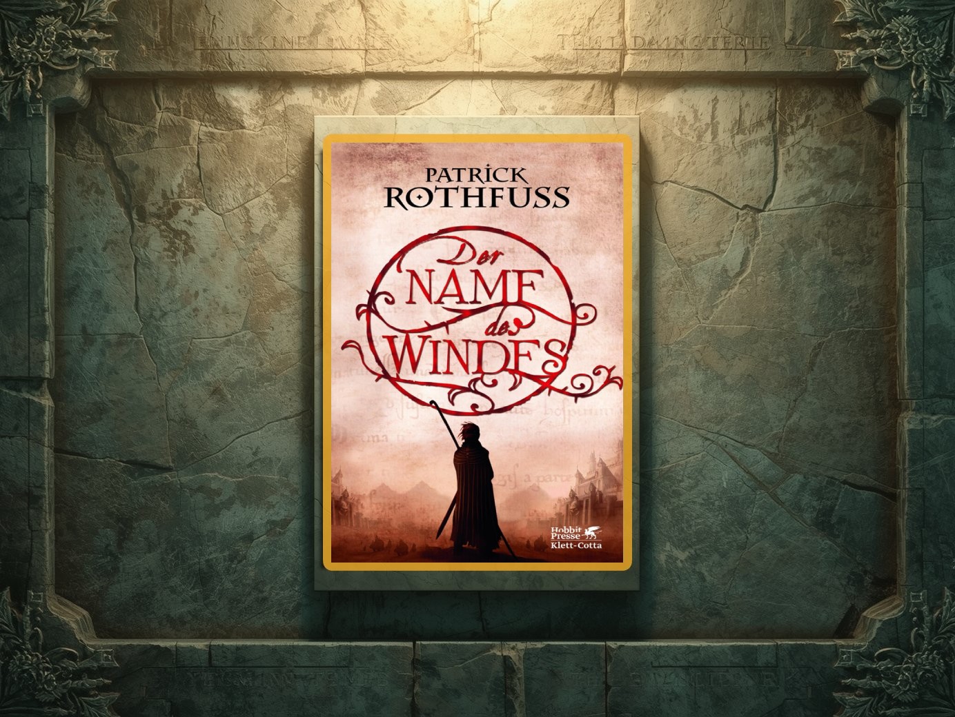 Cover der deutschen Ausgabe von Patrick Rothfuss Der Name des Windes, mit rotem verschlungenem Titelschriftzug in einem Kreis und der Silhouette eines Mantelträgers vor blassroter Landschaft, präsentiert wie ein gerahmtes Bild an einer steinernen Wand.