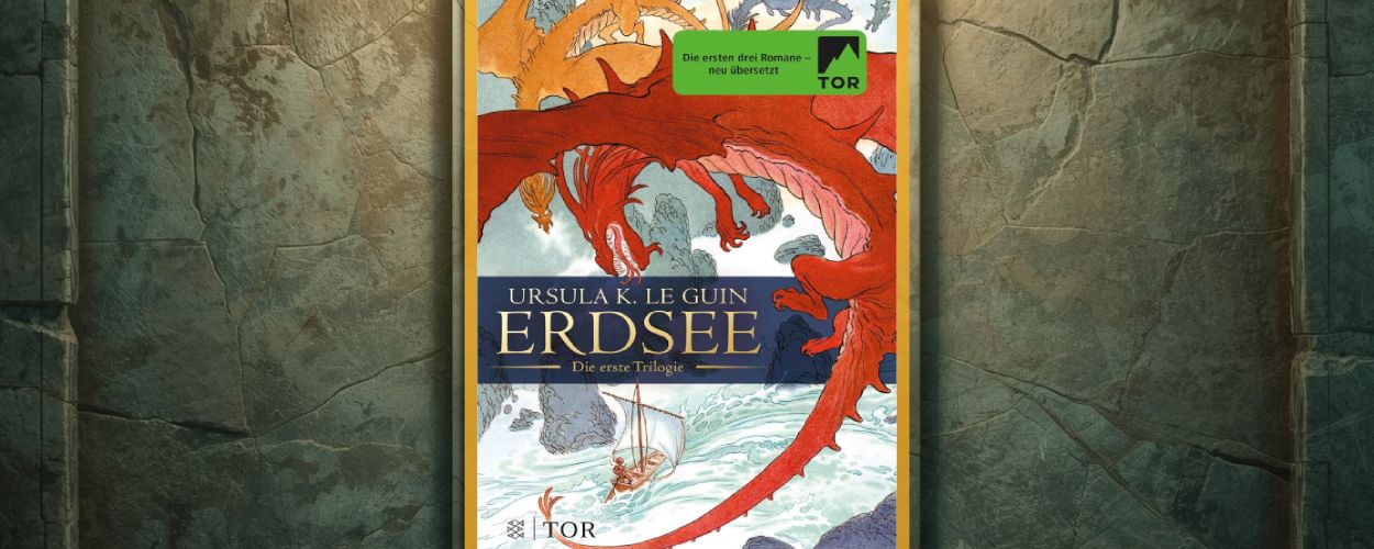 Buchcover „Erdsee – Die erste Trilogie“ von Ursula K. Le Guin mit roten Drachen über Meer und Segelboot, in goldenem Rahmen vor einer verwitterten Steinwand.