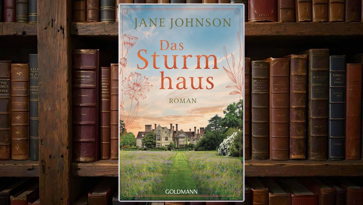 Buchcover von „Das Sturmhaus“ vor einem Regal mit alten Ledereinbänden: In der Mitte sieht man ein großes, herrschaftliches Landhaus im englischen Stil, umgeben von grünen Bäumen und einer weitläufigen Wiese mit lilafarbenen Blumen. Ein gerader Grasweg führt auf das Haus zu. Am Himmel liegt ein weiches Abendlicht mit blau-orangem Farb