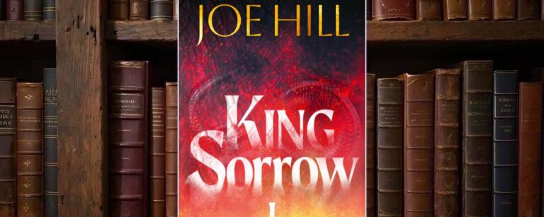 Dunkelblaues Cover von King Sorrow I mit stilisierten orange-roten Flammen auf fast schwarzem Grund; darüber und mittig große weiße Typografie mit Autorennamen und Titel.