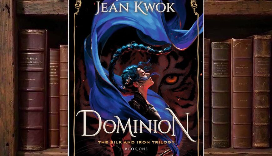 Cover von Jean Kwoks Dominion mit einer dunkelhaarigen Kriegerin, die von langen blauen Stoffbändern umkreist wird, vor dem gewaltigen Gesicht eines orangeäugigen schwarzen Tigers und einem goldenen ornamentalen Rahmen.