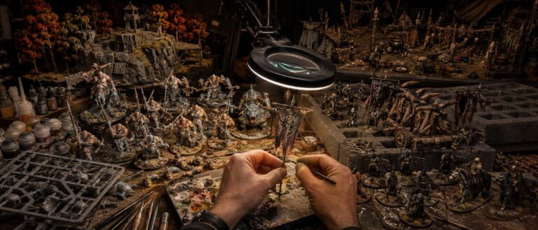 Neue Ogor-Miniaturen neben klassischen Uruk-hai und Heerführern aus Rohan auf einer Fantasy-Hobbywerkbank.