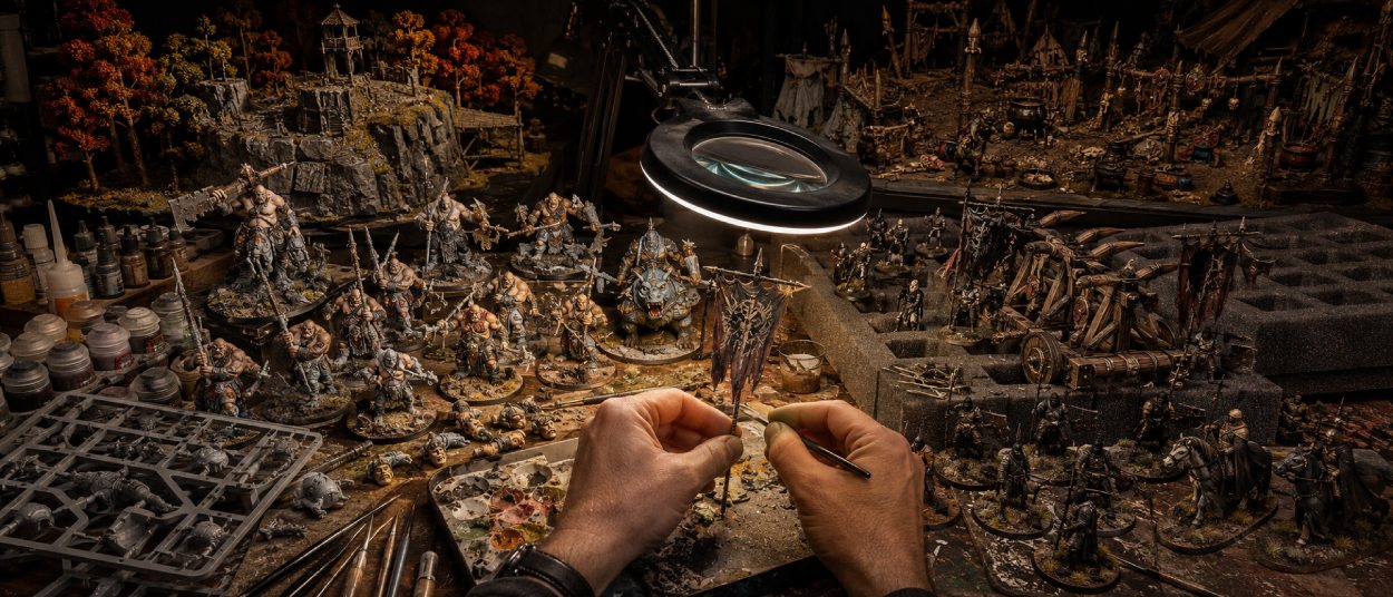 Neue Ogor-Miniaturen neben klassischen Uruk-hai und Heerführern aus Rohan auf einer Fantasy-Hobbywerkbank.