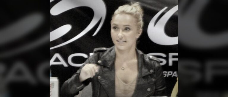 Hayden Panettiere sitzt bei einer Veranstaltung in einer schwarzen Lederjacke vor einem dunklen Hintergrund und blickt seitlich am Fotografen vorbei.