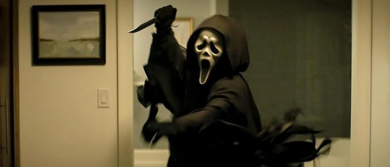 Ghostface stürmt mit erhobenem Messer durch einen hellen Wohnraum. Die schwarze Kutte weht hinter der Figur, während die weiße Maske frontal zu sehen ist.