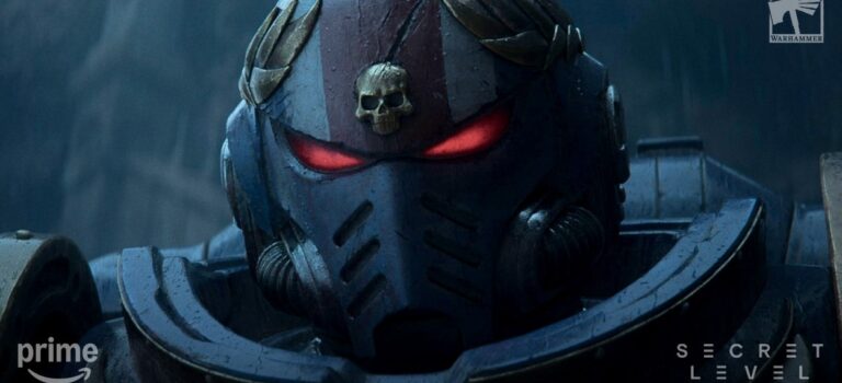 Nahaufnahme eines schwer gepanzerten Space Marines mit dunklem Helm, goldenem Totenkopfsymbol und rot leuchtenden Augen.