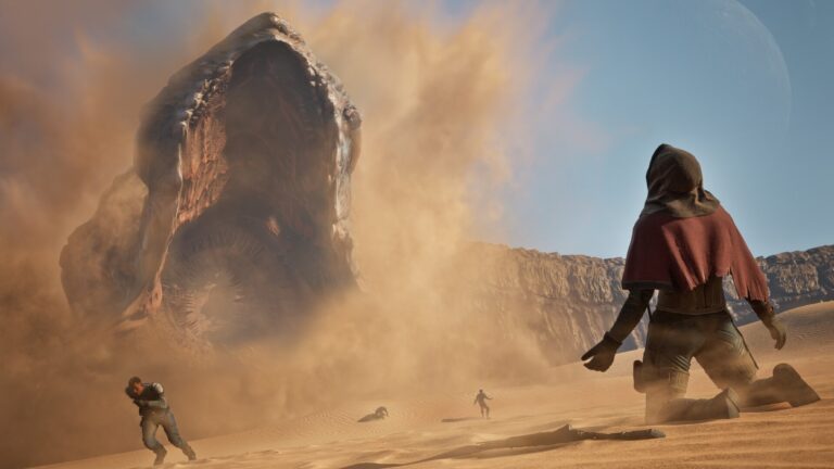 Eine einzelne vermummte Figur kniet in der Wüste von Arrakis, während ein gigantischer Sandwurm durch eine Staubwolke bricht und weitere Menschen über die Dünen fliehen.