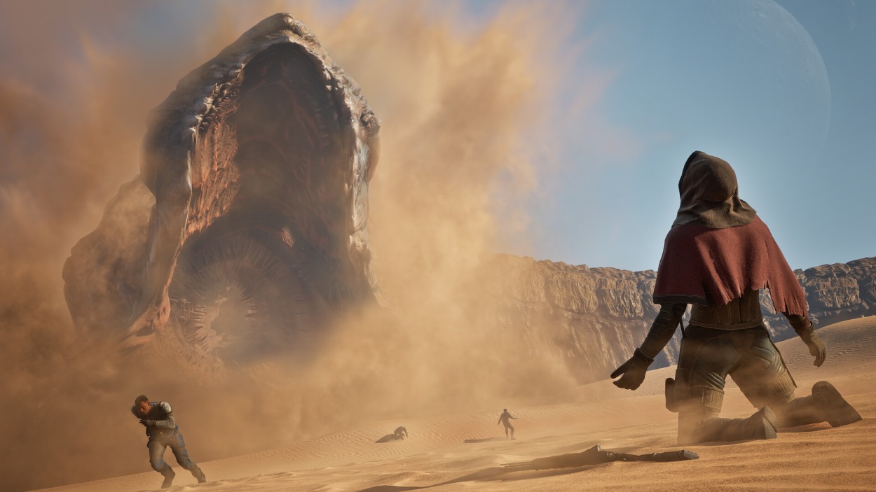 Eine einzelne vermummte Figur kniet in der Wüste von Arrakis, während ein gigantischer Sandwurm durch eine Staubwolke bricht und weitere Menschen über die Dünen fliehen.