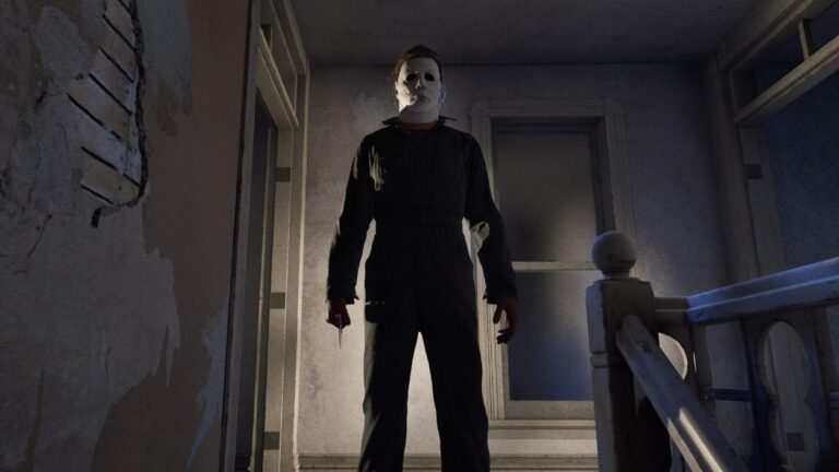 Michael Myers steht mit weißer Maske und Messer in einem düsteren Treppenhaus eines Wohnhauses.