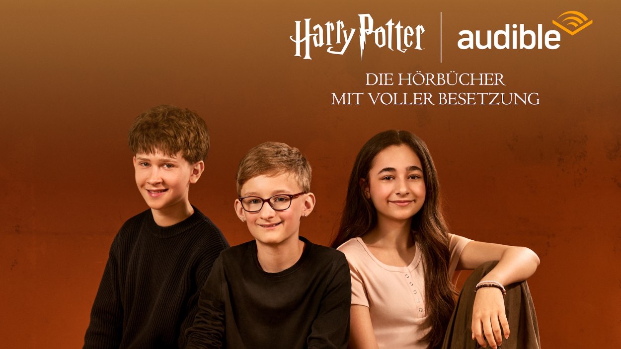 Drei junge Sprecher des deutschen Harry-Potter-Hörbuchensembles sitzen vor orangefarbenem Hintergrund unter dem Schriftzug „Harry Potter – Die Hörbücher mit voller Besetzung“ und dem Audible-Logo.