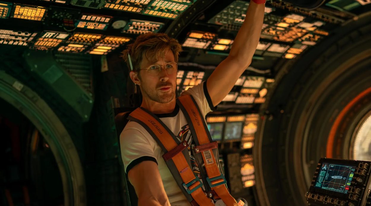 Astronaut sitzt angeschnallt im technisch dicht ausgestatteten Kontrollraum eines Raumschiffs im Science-Fiction-Film Project Hail Mary.