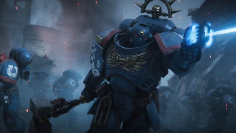 Mehrere Space Marines in blauer Rüstung stürmen durch eine rauchverhangene Schlacht, während der vorderste Krieger mit Energiewaffe und Kriegshammer angreift.