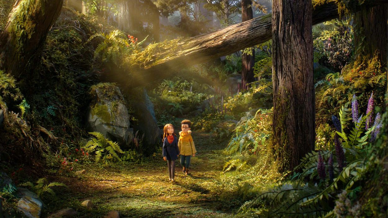 Prue und Curtis gehen in LAIKAs Wildwood durch einen üppigen, sonnenbeschienenen Fantasywald mit riesigen Bäumen und dichter Vegetation.