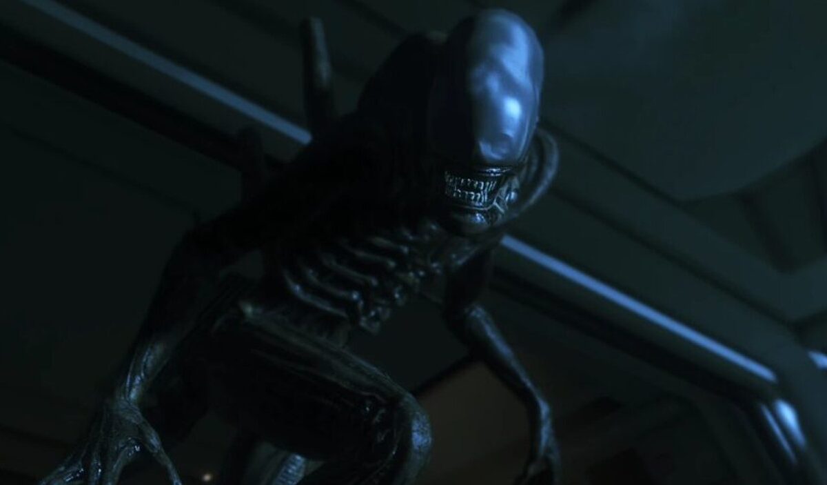 Ein Xenomorph aus Alien: Isolation 2 beugt sich in einem dunklen, metallischen Korridor bedrohlich nach vorn.