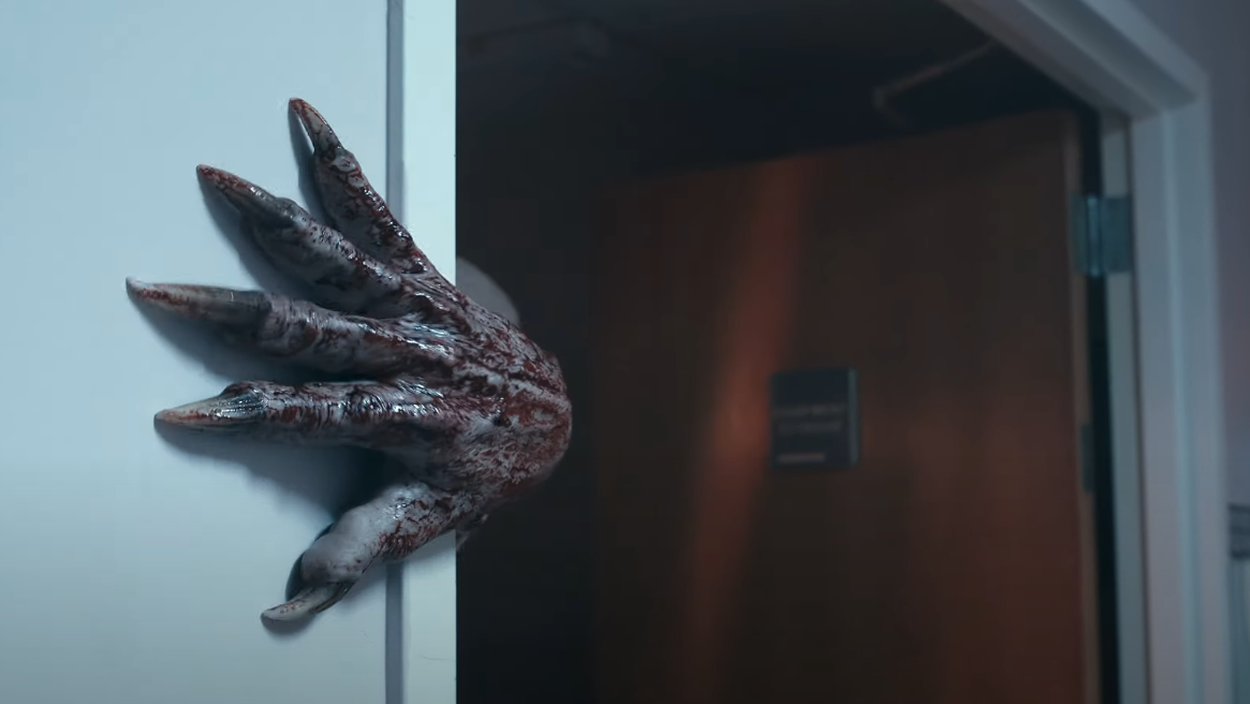 Eine blutverschmierte monströse Hand mit langen Klauen greift aus einem dunklen Türrahmen in Bunker Heights.