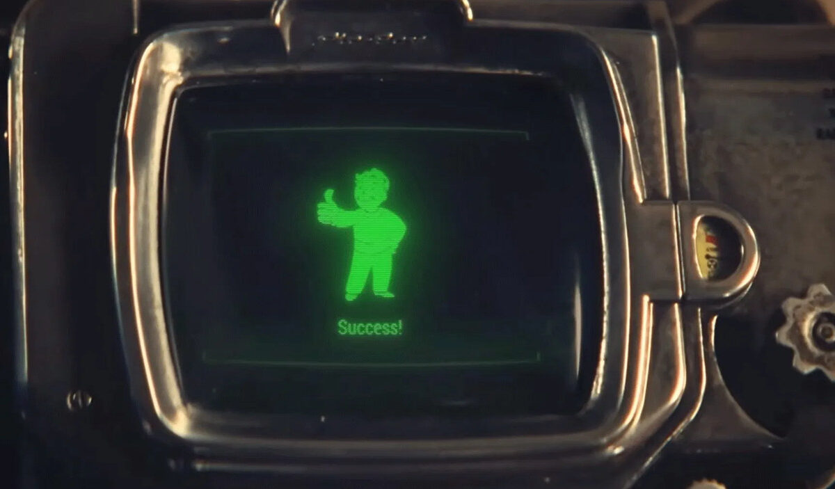 Nahaufnahme eines Pip-Boy-Geräts aus Fallout. Auf dem grün leuchtenden Bildschirm zeigt der Vault Boy den erhobenen Daumen. Darunter erscheint die Meldung „Success!“. Szene aus dem Teaser zu Fallout Shelter: The Experiment.