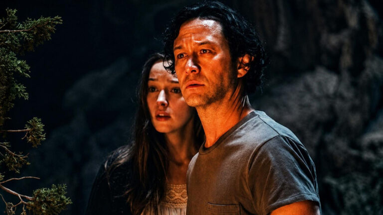 Filmszene aus Pendulum: Joseph Gordon-Levitt und Phoebe Dynevor sitzen angespannt in einem warm beleuchteten Raum und blicken nervös in dieselbe Richtung.
