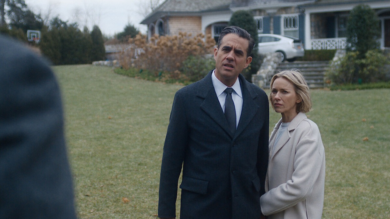 Ein angespannt wirkendes Paar steht vor einem großen Vorstadthaus in einer Szene aus der Netflix-Mysteryserie The Watcher.