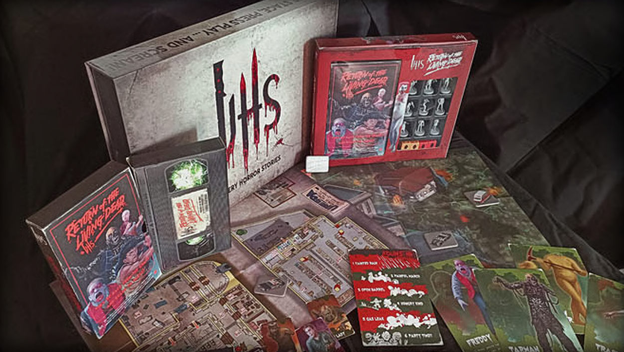 Produktaufnahme des Horror-Rollenspiels VHS: Return of the Living Dead von Aces Games. Zu sehen sind eine große VHS-Spielbox, eine rote Return-of-the-Living-Dead-Box sowie ausgebreitete Spielpläne, Regelhefte und farbige Charakter- und Monsterkarten.