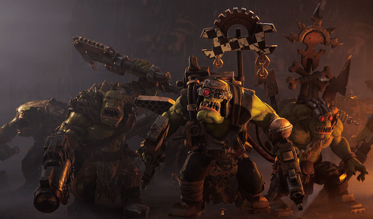 Mehrere bewaffnete Orks aus Warhammer 40.000: Dawn of War IV stürmen durch eine düstere, orange beleuchtete Kriegsszene. Im Vordergrund stehen schwer bewaffnete Grünhäute mit Metallrüstungen, Waffen und Ork-Bannern.