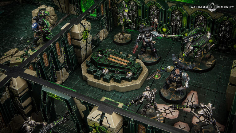 Tabletop-Spielfeld aus Warhammer 40.000: Kill Team mit bemalten Deathwatch-Space-Marines und Necron-Kriegern zwischen hohen Mauern und Deckungen einer grün beleuchteten Tomb-World-Gruftwelt.
